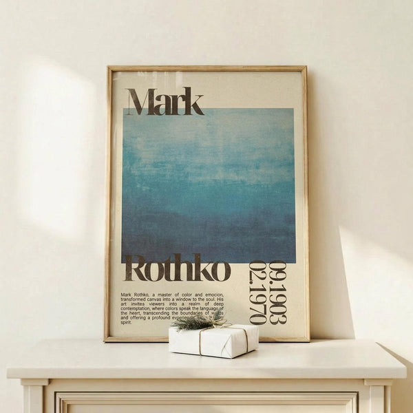 May include: Framed poster featuring Mark Rothko's name and exhibition details with a blue gradient square artwork transitioning from light blue at top to deep navy at bottom. The minimalist print has vintage exhibition text and dates. Shown in light wood frame on white wooden dresser next to small wrapped gift with twine bow against cream wall.