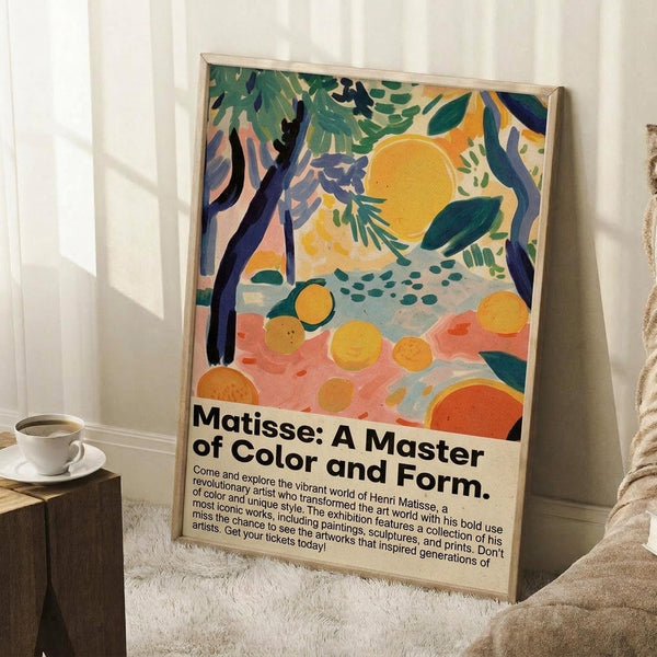 May include: Framed poster with vibrant Matisse-inspired artwork featuring orange circles, green foliage, dark tree trunks, and coral-pink ground in fauve style. Black exhibition text below reads "Matisse: A Master of Color and Form" with description. Light wood frame leaning against white wall corner beside beige armchair and coffee cup on wooden side table.