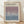 May include: Framed exhibition poster for Mark Rothko at Rothko Art Gallery, New York City, featuring a gradient color field transitioning from mauve purple at top to dusty blue at bottom. Light wood frame with cream matting, leaning against white wall on light wooden floor with natural sunlight shadows. Exhibition dates April 15 - July 30, 2023 at 6:00 PM printed below the artwork.