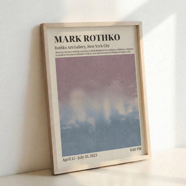 May include: Framed art exhibition poster featuring Mark Rothko's name in bold black text at top, with gallery information and exhibition dates below. The center displays a soft gradient artwork transitioning from dusty purple at top to pale blue at bottom. Light wood frame against white wall with natural lighting creating gentle shadows.