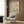 a modern living room with a white armchair, a floor lamp, and a framed poster on the wall.