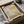 a framed poster of an abstract painting, which appears to be a promotional poster for an art exhibition. The poster is placed in a cardboard box, and there is a clear plastic wrapping around it.