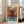 May include: Framed abstract art print in light wood frame leaning against white wall next to beige sofa. Artwork features bold orange, turquoise blue, and burgundy brushstrokes in Mark Rothko's style with "MARK ROTHKO" text at top. Natural light streams through windows onto hardwood floors in modern living room setting.