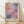 May include: Framed poster print featuring abstract watercolor artwork with soft pink, purple, and blue rectangular color blocks in gradient wash style. Light wood frame with cream matting displays "MARK ROTHKO" text below artwork. Print leans against white wall on natural wood floor with sunlight casting diagonal shadows across cream textured wall.