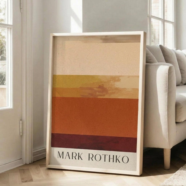 May include: Framed poster with horizontal color blocks in cream, yellow, orange, and burgundy tones in Mark Rothko's abstract expressionist style, displayed in bright living room corner next to beige upholstered sofa with throw pillows near tall windows with natural light streaming across white walls and light wooden floors.