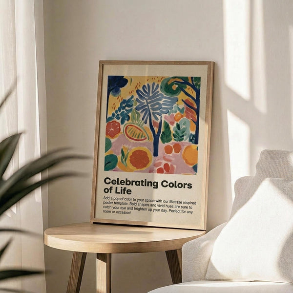 May include: Framed poster with colorful botanical artwork featuring tropical leaves, fruits, and plants in vibrant blues, oranges, greens, and pinks displayed on a round wooden side table next to a beige upholstered chair with decorative pillow, palm plant visible in corner, natural sunlight streaming across neutral wall creating soft shadows