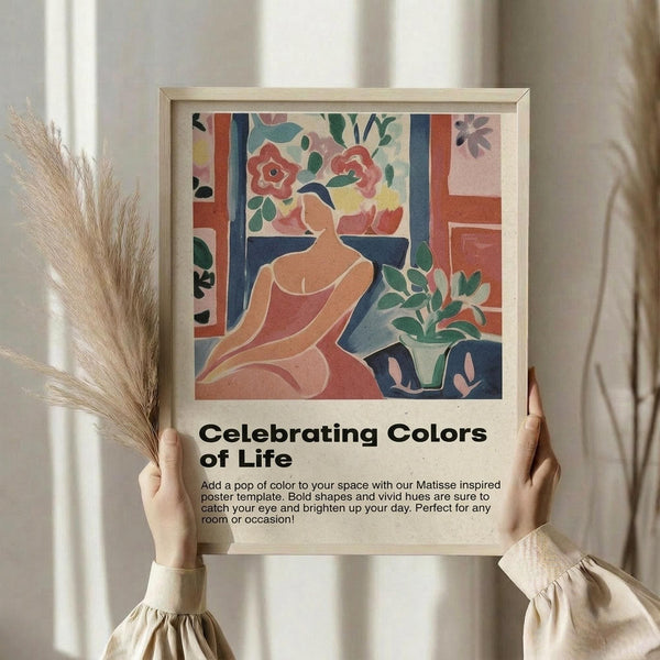 May include: Person in cream ruffled sleeves holding framed poster featuring abstract woman in coral dress surrounded by colorful flowers and foliage in Matisse-inspired style. Light wooden frame against neutral curtained background with dried wheat stems visible. Bold geometric shapes in coral, blue, green, and pink tones create vibrant artistic composition.