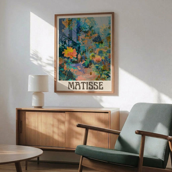 May include: Framed art print featuring vibrant tropical garden scene with lush foliage in blues, greens, yellows and coral tones, displayed above mid-century modern wooden credenza with ceramic table lamp. Mint green upholstered armchair with wooden frame sits nearby on light wood floors. Warm natural sunlight creates geometric shadows on white wall, showcasing the colorful botanical artwork in wooden frame.