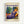 May include: Framed poster print displayed against white wall showing Henri Matisse exhibition artwork. Features woman in purple patterned dress and orange head wrap reclining among potted plants. Vibrant colors include blues, greens, oranges, and purples in Matisse's distinctive style. Text reads "MATISSE," "Musées Matisse," "06200 NICE, FRANCE," and "Tribute to a Master." Light wood frame visible around cream-colored poster.