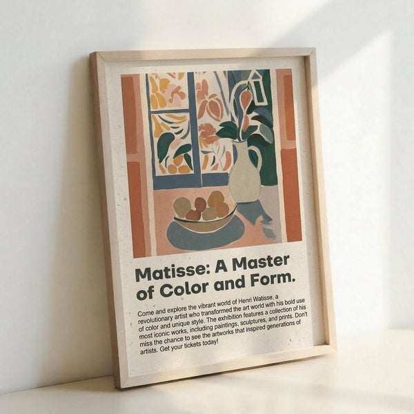 May include: Framed art print leaning against white wall showing Matisse-style still life with window view, vase of flowers, and fruit bowl in muted earth tones of coral, green, and cream. Below the artwork is black text reading "Matisse: A Master of Color and Form" with exhibition-style descriptive paragraph. Light wood frame with cream matting, natural lighting creates soft shadows.