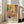 May include: Colorful Matisse-inspired poster in white frame leaning against wall next to beige sofa. Artwork features vibrant interior scene with patterned chair, blue vase with palm fronds, tropical plants, and geometric wall tiles in yellow, pink, and coral tones. Bold black "MATISSE" text at bottom.