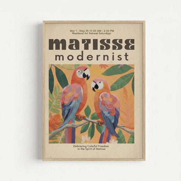 Framed poster with cream background featuring two colorful parrots perched on a branch surrounded by tropical leaves. The parrots display vibrant orange, pink, blue and purple feathers in a stylized artistic manner. Text reads "matisse modernist" in bold brown letters, with event details "Mar 1 - May 25 10:00 AM - 2:30 PM Weekend Art Retreat Saturdays" above and "Embracing Colorful Freedom In the Spirit of Matisse" below the artwork. Light wood frame against white wall.