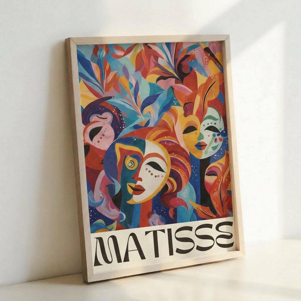 May include: Framed poster print leaning against white wall showing vibrant abstract artwork with stylized faces and foliage in bold colors including blues, reds, oranges, and yellows. The composition features mask-like faces with decorative patterns surrounded by flowing leaf motifs. Text reading "MATISSE" appears at bottom in black letters. Natural wood frame visible around edges.