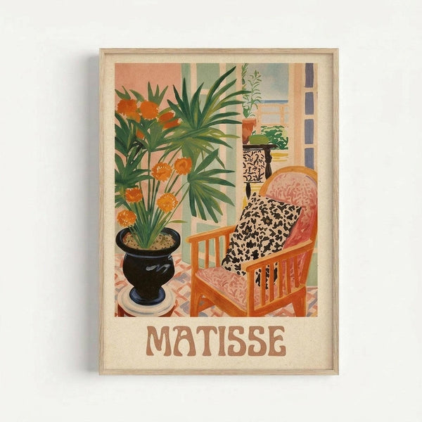 Framed art print in light wood frame showing an interior scene with orange flowers in a black vase, wooden chair with leopard print cushions, and lush green plants. The artwork features warm coral, green, and cream colors in a flat, decorative style. "MATISSE" appears in brown letters below the image on a cream background.