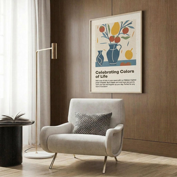 May include: Framed poster with colorful Matisse-style still life featuring blue vases, red apples, yellow pear and fruits with green leaves on cream background, displayed on warm wood paneled wall above beige upholstered armchair with geometric patterned pillow, beside brass floor lamp and black side table with open book