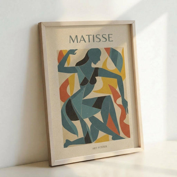 Framed art poster featuring an abstract blue figure in Matisse's cut-out style, with curved organic shapes in teal, navy, yellow and orange against a cream background. The wooden frame sits propped against a white wall, showing the poster's vertical rectangular format with "MATISSE" and "ART POSTER" text.