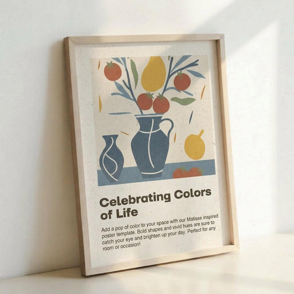 Framed poster with Matisse-inspired still life artwork featuring blue ceramic vases, red apples, yellow pear, and leafy branches in a modern cut-paper collage style. The cream-colored print includes text reading "Celebrating Colors of Life" with descriptive copy below. Natural wood frame sits propped against white wall, casting soft shadows.