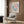 a living room with a white armchair, a floor lamp, and a framed poster of a colorful abstract painting hanging on the wall.