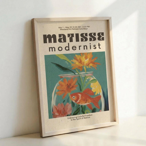 May include: Framed poster with cream mat featuring colorful Matisse-style artwork of orange goldfish in glass fishbowl with vibrant flowers - yellow, orange, and pink blooms against turquoise background. Bold "matisse modernist" typography at top with exhibition details. Natural wood frame leaning against white wall in bright lighting.
