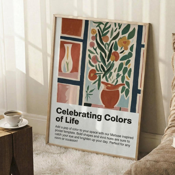 May include: Framed poster leaning against white wall corner featuring Matisse-inspired artwork with colorful vases, plants, and geometric shapes in warm oranges, greens, and blues. White text below reads "Celebrating Colors of Life" with descriptive paragraph. Small wooden table with white coffee cup visible on left, cream textured rug underneath, cozy room setting with natural window light.