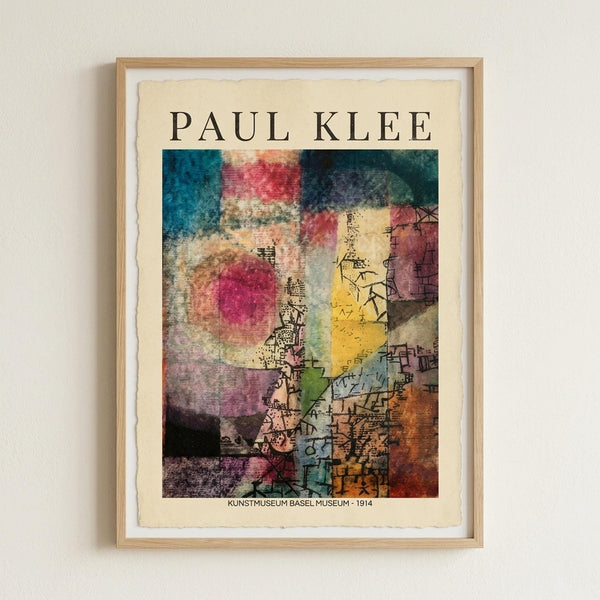 May include: Framed art print hanging on white wall featuring Paul Klee's abstract watercolor artwork with vibrant geometric shapes in blues, reds, yellows, and earth tones. The composition shows overlapping translucent forms and delicate line work characteristic of Klee's style. Text reads "PAUL KLEE" at top and "KUNSTMUSEUM BASEL MUSEUM - 1914" at bottom on cream-colored paper with natural wood frame.