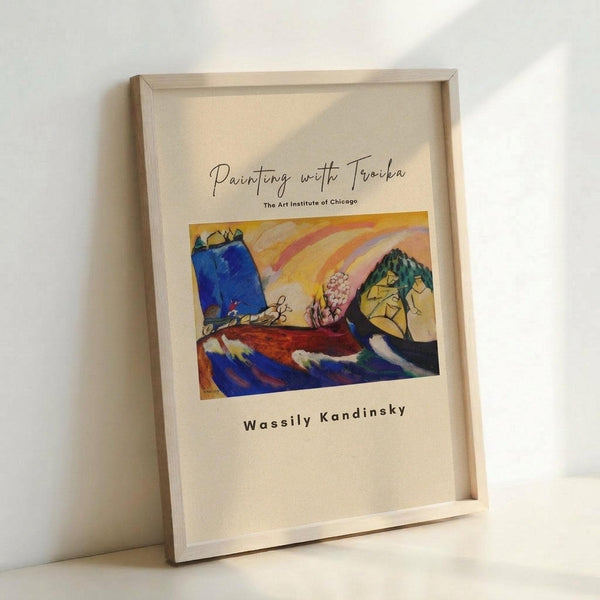 May include: Framed art print leaning against white wall showing abstract expressionist painting with vibrant blues, yellows, and rainbow arcs. Features geometric yellow mountain-like form, blue rectangular shapes, and flowing curved lines in warm colors. Natural wood frame on cream colored paper with cursive text above artwork and artist name below.