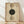 May include: Framed abstract geometric poster with vertical arrangement of circles in olive green, tan, and dark forest green on aged beige background. Features concentric curved lines, dotted elements, and "MODERN" and "BAUHAUS" text along right edge. Natural wood frame leaning against white wall on light wooden floor with soft window lighting.