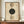 May include: Framed geometric poster with cream background featuring vertical arrangement of circles in sage green, tan, and dark forest green. Design includes concentric lines, dots, and "MODERN" and "BAUHAUS" text. Wood frame displayed on walnut credenza beside white ceramic vase and stacked books in elegant room with white wainscoting.