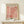 May include: Framed art print featuring coral pink cut-out leaf and botanical shapes in Matisse's signature paper collage style, displayed on light wood furniture next to a small wrapped gift with greenery. The poster has "MATISSE" at top and "PAPIERS DÉCOUPÉS" at bottom in black text, set in a thin wooden frame against cream colored wall.