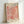 May include: Framed art print featuring coral-colored organic flowing shapes in Matisse's cut-out paper style against cream background, displayed in light wood frame leaning against white wall corner. Abstract botanical forms create dynamic movement across the composition with "MATISSE" and "PAPIERS DÉCOUPÉS" text at top and bottom.