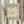 May include: Person in cream blouse holding framed art print featuring large white abstract flower shape on sage green background with "MATISSE" and "PAPIERS DÉCOUPÉS" text, shown with dried pampas grass against white curtained window in natural lighting
