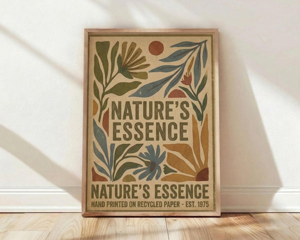 May include: Framed vintage-style botanical poster with earth-toned leaf and plant motifs surrounding bold text reading "Nature's Essence" on cream background, displayed against white wall on light wood floor with natural sunlight casting diagonal shadows across the scene.