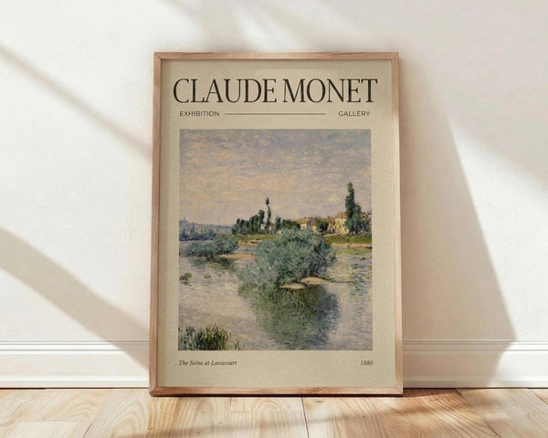 May include: Framed vintage-style exhibition poster featuring Claude Monet's impressionist landscape painting of a river scene with green foliage and soft cloudy sky, displayed against white wall on light wooden floor with natural window shadows