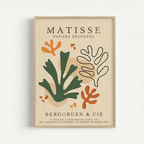 Framed exhibition poster featuring Matisse's cut-paper artwork in abstract organic shapes. Green seaweed-like forms, orange coral shapes, and tan outlined botanical elements arranged on cream background. Text reads "Matisse Papiers Découpés" and "Berggruen & Cie" with Paris gallery details and 1953 exhibition dates. Light wood frame against white wall.
