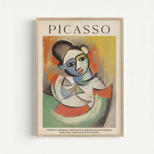 May include: Framed Picasso-style cubist portrait print displayed on white wall. Artwork features abstract female figure with geometric face in blue, yellow, and white tones against colorful orange, yellow, and green background. Light wood frame with cream matting. French text below image describes contemporary artistic creations inspired by Picasso's techniques and ideas.