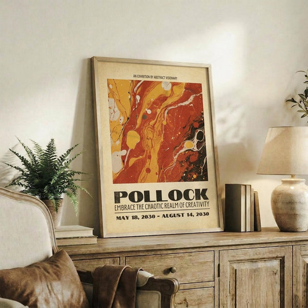 May include: A framed abstract art poster with swirling orange, red, and yellow paint patterns displayed on a rustic wooden sideboard. The artwork features fluid, marbled textures in warm autumn tones with black accents. The poster is propped against a white wall alongside a small fern plant, stacked books, and ceramic pottery, creating a cozy living room vignette with earth-toned furniture and soft natural lighting.