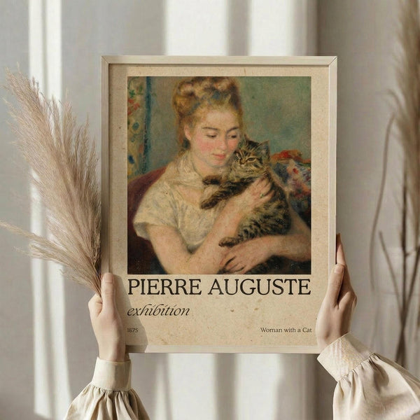 May include: Hands holding a framed vintage art print featuring a blonde woman in cream clothing embracing a tabby cat, with "PIERRE AUGUSTE exhibition" and "1875 Woman with a Cat" text below the image. Neutral beige frame against white curtained window with dried wheat stems visible on left side.