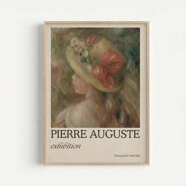 Framed art print featuring a soft, impressionistic painting of a young woman in profile wearing a decorative hat with flowers. The artwork displays muted tones of pink, green, and cream with loose, flowing brushstrokes. Below the image, "PIERRE AUGUSTE" appears in bold black letters with "exhibition" in smaller italic text, and "Young Girl with Hat" in the bottom right corner. The print has a light wooden frame and is photographed against a white wall.
