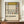 May include: Framed abstract art poster with geometric grid pattern in black lines, featuring yellow, blue, and red rectangular sections on cream background. Exhibition-style text reads "PIET MONDRIAN The Art of Abstraction 1938-1943 Place de la Concorde" below the artwork. Displayed on wooden sideboard next to white ceramic vase and stacked books in elegant room with cream walls and white molding.