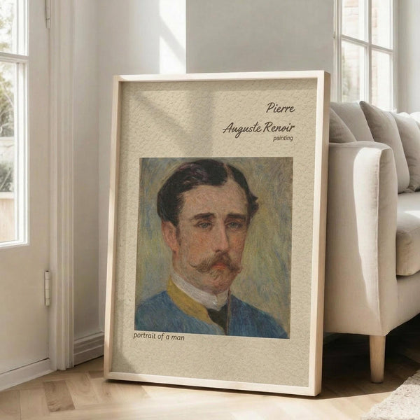 May include: Framed vintage portrait painting of a man with mustache wearing blue jacket, displayed in light wooden frame against beige textured mat, leaning against beige upholstered chair in bright sunlit room with white walls and large windows