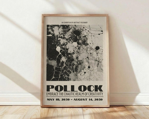 May include: Framed abstract art poster with black and white splattered paint design in wooden frame, leaning against white wall on light wood floor. Soft natural lighting creates shadows across the scene. Poster features organic splatter patterns and bold text reading "POLLOCK" with exhibition details below.