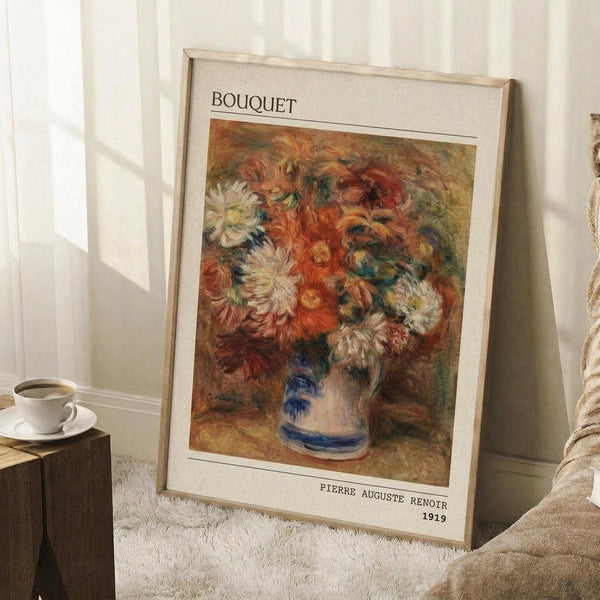 May include: Framed art print of an Impressionist floral painting leaning against white wainscoting wall. Features vibrant bouquet with orange, red, and white flowers in blue-striped ceramic vase, painted in loose brushstrokes. Cream matting with "BOUQUET" at top and "PIERRE AUGUSTE RENOIR 1919" at bottom. Wooden side table with white coffee cup and saucer visible on left, beige textured rug below, cozy home interior setting.
