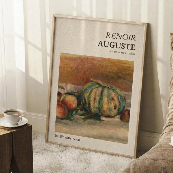 May include: Framed art print of Renoir's still life painting featuring a large striped melon and peaches in warm earth tones, displayed on white textured rug against white wall corner. Wooden side table with white coffee cup and saucer visible nearby, with beige fabric in corner.
