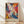 May include: Framed abstract expressionist poster with vibrant swirling paint in blues, oranges, purples, yellows and white against cream background. Text reads "POLLOCK Expressive Expressionist Movement" below colorful fluid artwork. Natural wood frame sits on light wooden floor against white wall with soft window light creating diagonal shadows.