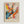May include: Abstract expressionist art poster with energetic paint splatters and drips in vibrant orange, blue, yellow, pink and black against cream background, displayed in light wood frame on white wall. Dynamic brushstrokes and scattered dots create explosive movement radiating from center, with "POLLOCK" and "Expressive Expressionist Movement" text below artwork.