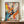 May include: Abstract expressionist poster with dynamic paint splatters and brushstrokes in vibrant orange, blue, yellow, pink, and black on cream background. Text reads "POLLOCK Expressive Expressionist Movement" at bottom. Framed in thin brown frame, displayed on wooden console table next to white ceramic vase and stacked books in elegant room with cream walls and white molding.