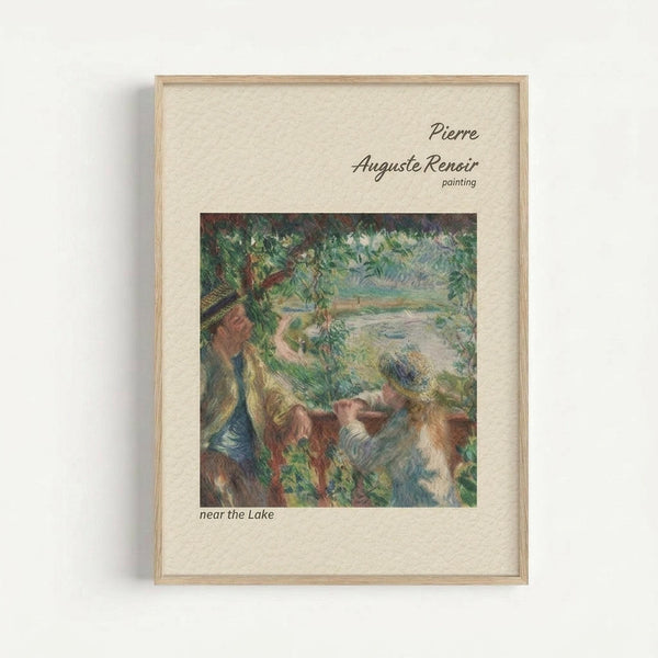 May include: Framed reproduction of Renoir's impressionist painting showing figures by a lake, displayed in a light wood frame with cream matting against a white wall. The artwork features soft brushstrokes in greens, blues, and earth tones depicting people relaxing near water surrounded by lush foliage.