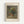 A vintage-style reproduction print of Renoir's floral still life painting displayed in a light wooden frame against a white wall. The artwork shows a ceramic vase filled with wildflowers in soft yellows, whites, reds, and blues, painted in an impressionistic style with muted earth tones. Text above reads "FLOWERS IN A VASE" and below shows "PIERRE AUGUSTE RENOIR 1866" in simple black lettering on cream-colored matting.