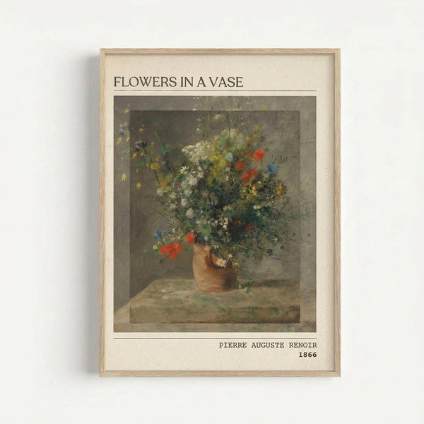 A vintage-style reproduction print of Renoir's floral still life painting displayed in a light wooden frame against a white wall. The artwork shows a ceramic vase filled with wildflowers in soft yellows, whites, reds, and blues, painted in an impressionistic style with muted earth tones. Text above reads "FLOWERS IN A VASE" and below shows "PIERRE AUGUSTE RENOIR 1866" in simple black lettering on cream-colored matting.
