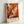 May include: Abstract expressionist art poster in light wood frame leaning against white wall. Features dynamic splashes and drips of orange, red, black and white paint creating energetic movement across the canvas. Bold brushstrokes and paint splatters create textured layers. Text at bottom reads "POLLOCK" and "Expressive Expressionist Movement" in clean typography below the vibrant artwork.